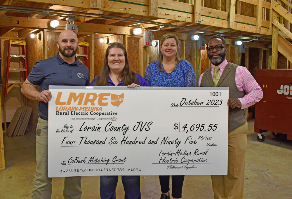 LCJVS Industrial electricty instructor, LCJVS administration and representative from LMRE stand with large grant check