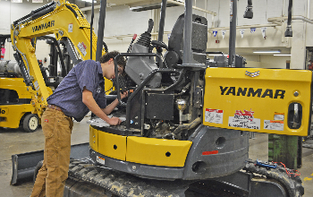 Josh Morlock works to debug a mini excavator in the District 2 Agricultural and Power Diagnostic Competition