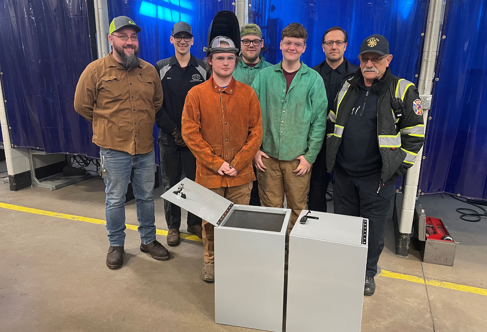 From left: LCJVS Welding and Fabrication instructor, Tony Tyree; senior students in the LCJVS Welding and Fabrication program, Amherst Assistant Fire Chief, Brandon Dimacchia and Amherst Fire Chief Jim Wilhelm stand by the storage lockers.