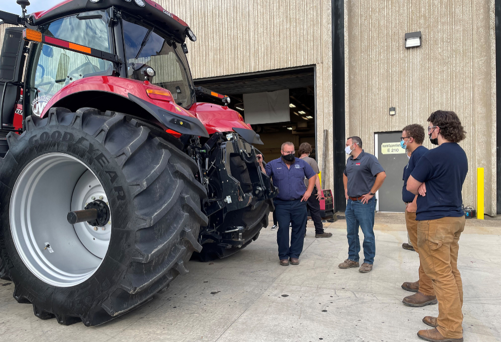 Lorain County JVS Industrial Equipment Mechanics students talk with Tom Stannard and their instructor, Mason Bremke about the tractor donation 