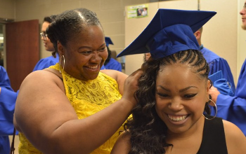 Female family members helps graduate put her cap on
